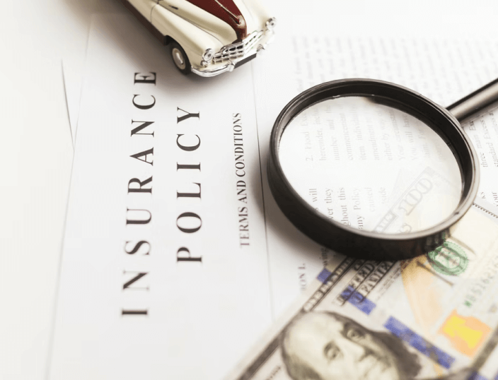Car insurance policy with magnifier, retro car toy and cash.