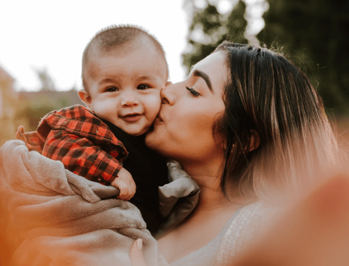 mother holding and kissing son